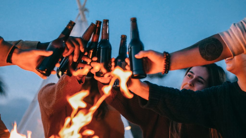 People toasting with beer bottles