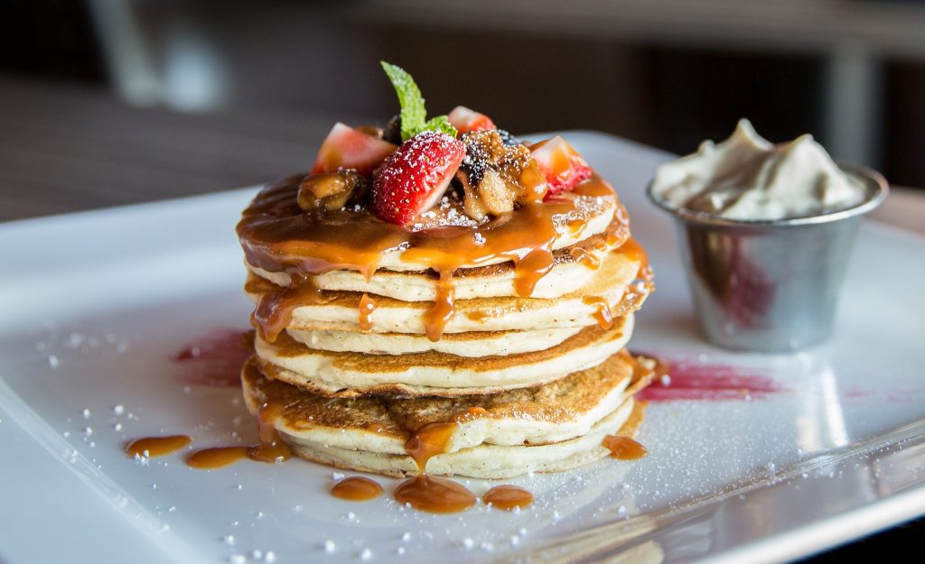 Stack of pancakes with syrup and fruit