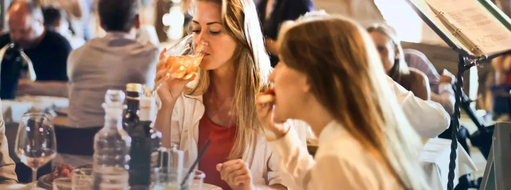 Two people eating and drinking in a restaurant